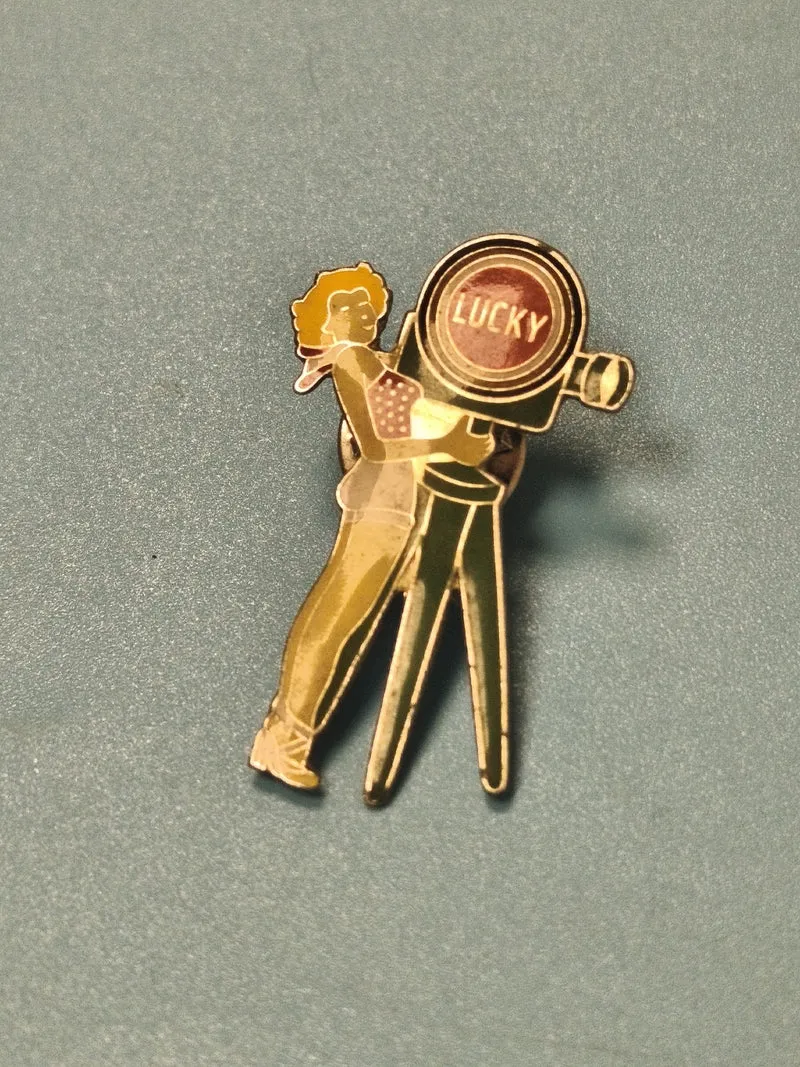 Vintage pin's Lucky Strike publicitaire femme caméra rétro collection
