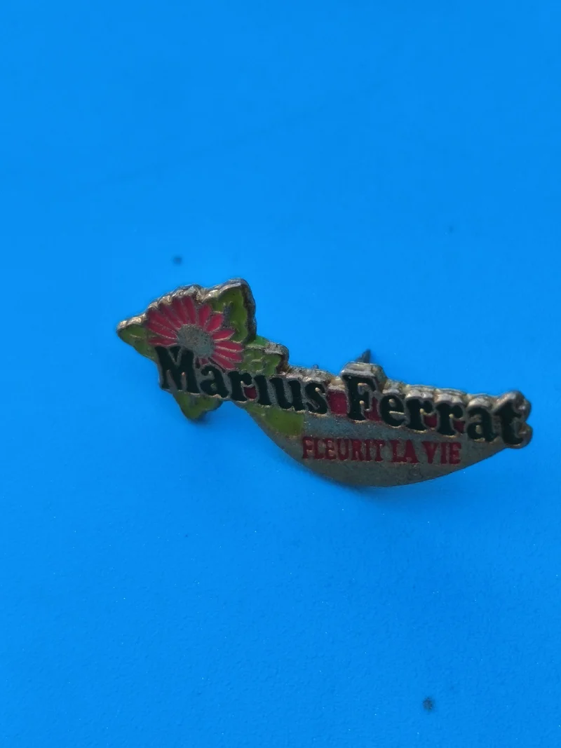 Pin's vintage Marius Ferrat fleur colorée ? collection publicitaire ancien