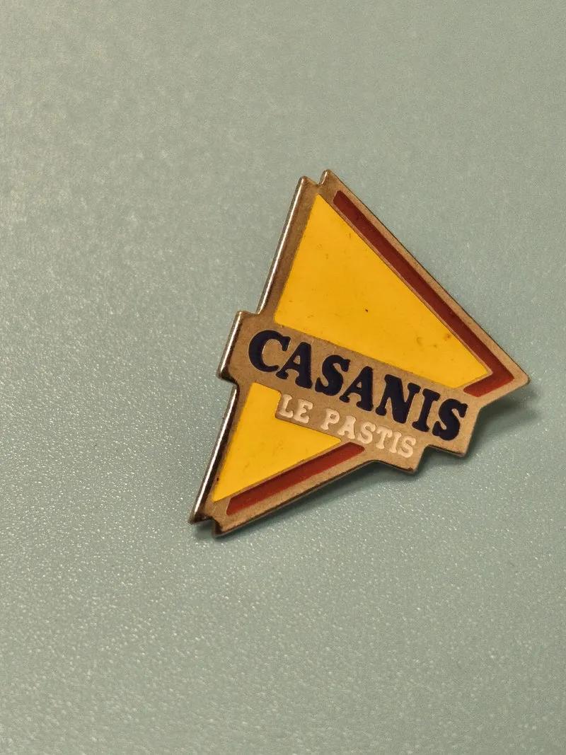 Pin's vintage Casanis Le Pastis triangle jaune publicitaire ancien collection