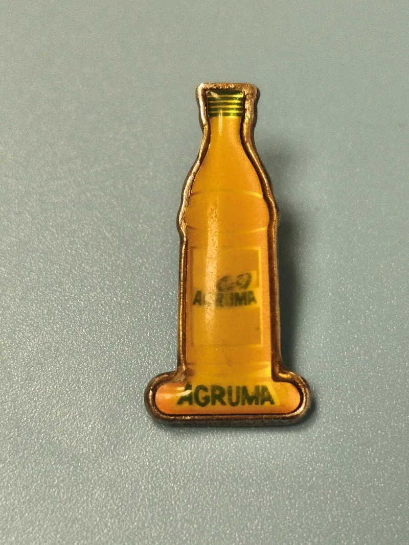 Pin's vintage AGRUMA bouteille soda jaune rétro boisson publicitaire collection