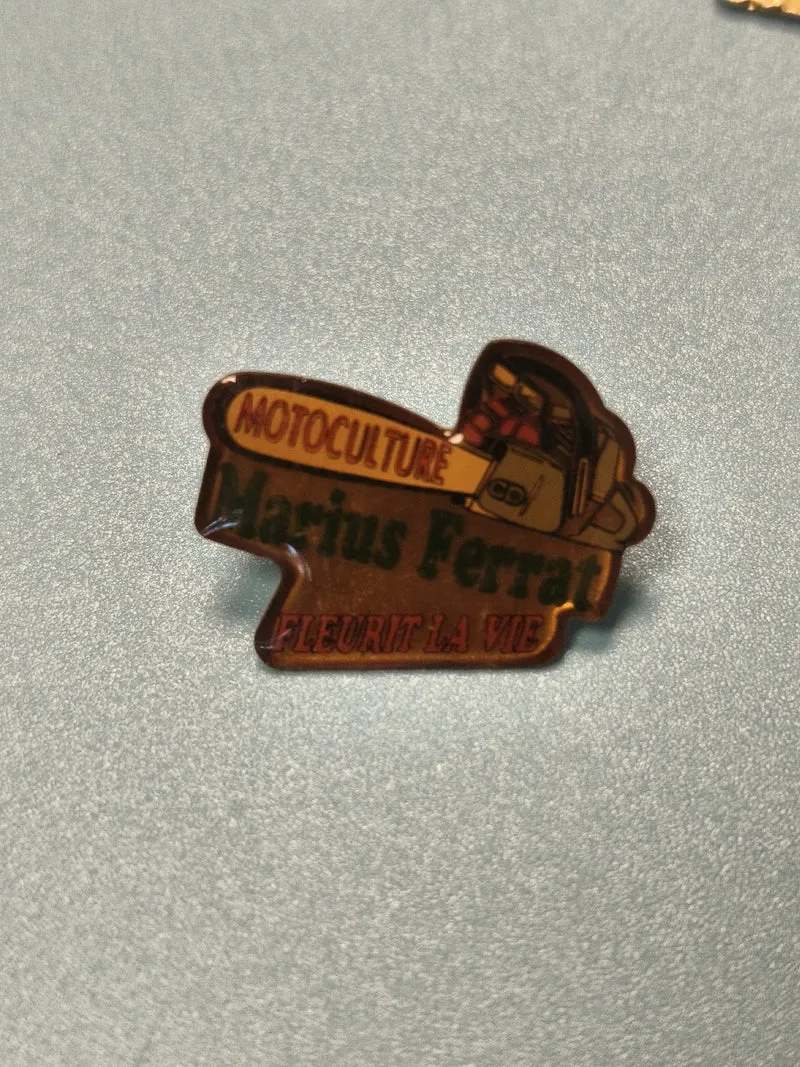 Pin's vintage Marius Ferrat moticulture, forme tronçonneuse, collection publicit