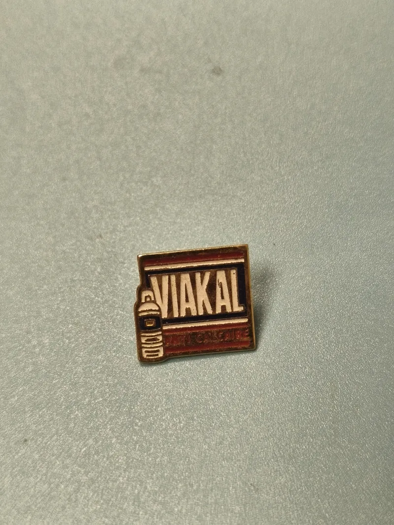 Pin's publicitaire vintage Viakal anti-calcaire, carré, couleurs bleu et rouge