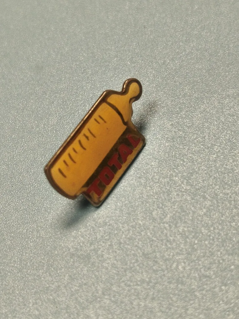 Pin's vintage TOTAL biberon jaune, collection publicitaire ancien ref 10