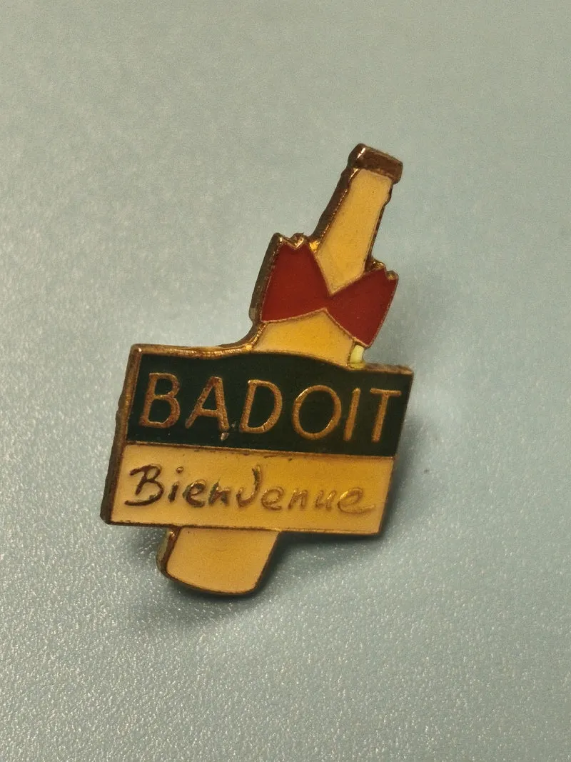 Pin's vintage Badoit Bienvenue bouteille jaune et rouge collection boisson minér
