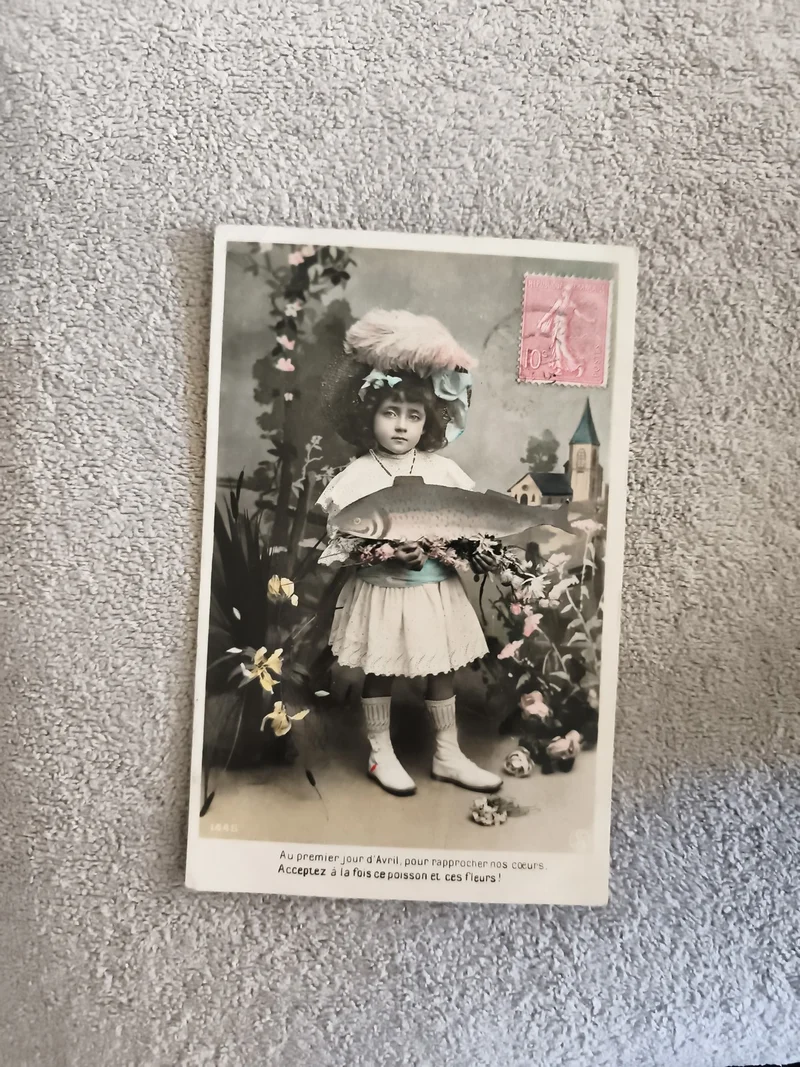 CPA poisson d'avril fillette chapeau plume fleurs timbre rose illustrée