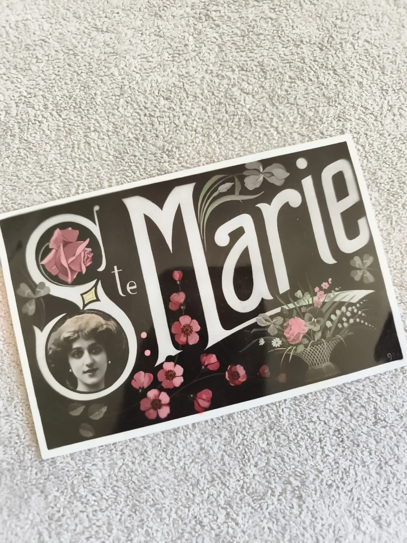 Carte postale Ste Marie illustrée portrait femme fleurs CPA