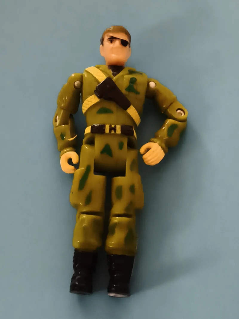 Figurine articulée militaire Gi Joe tenue camouflage vert bandeau œil