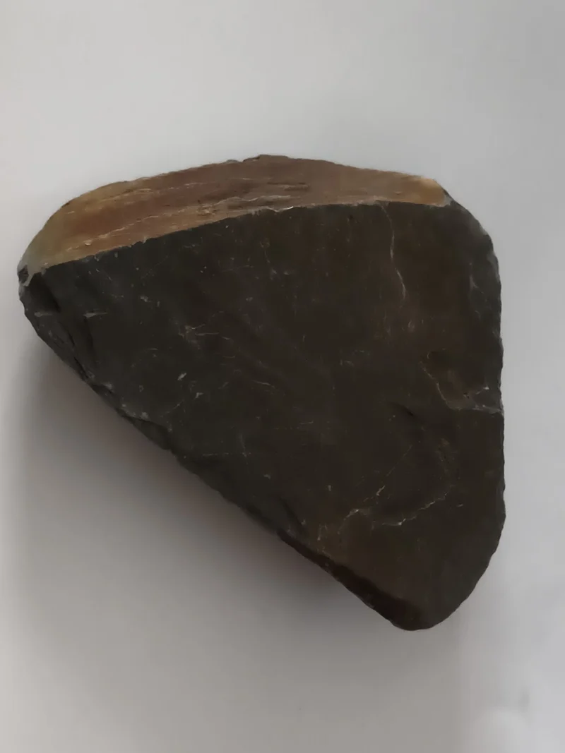 Pierre brute aspect ardoise noire, forme triangulaire, tranche beige