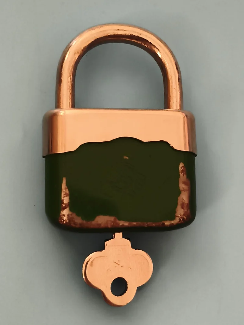 Cadenas ancien vert et cuivre avec clé, style rétro, serrure vintage sécurité