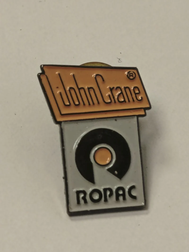 Pin's rétro ancien John Crane badge collection vintage rare objet publicitaire