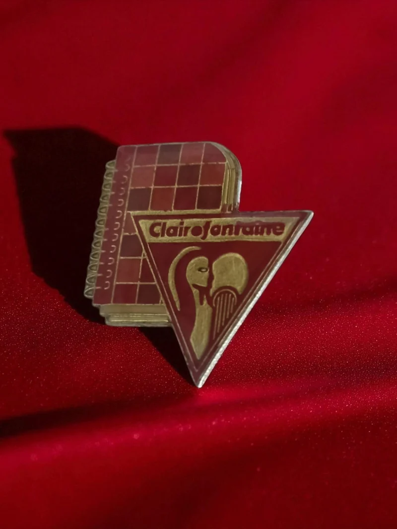 Pin's publicitaire vintage Clairefontaine ancien, badge rétro papeterie, rouge d