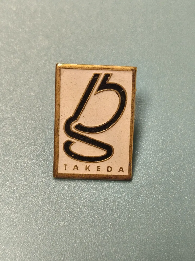 Pin's vintage Takeda rectangulaire logo noir et doré collection rare